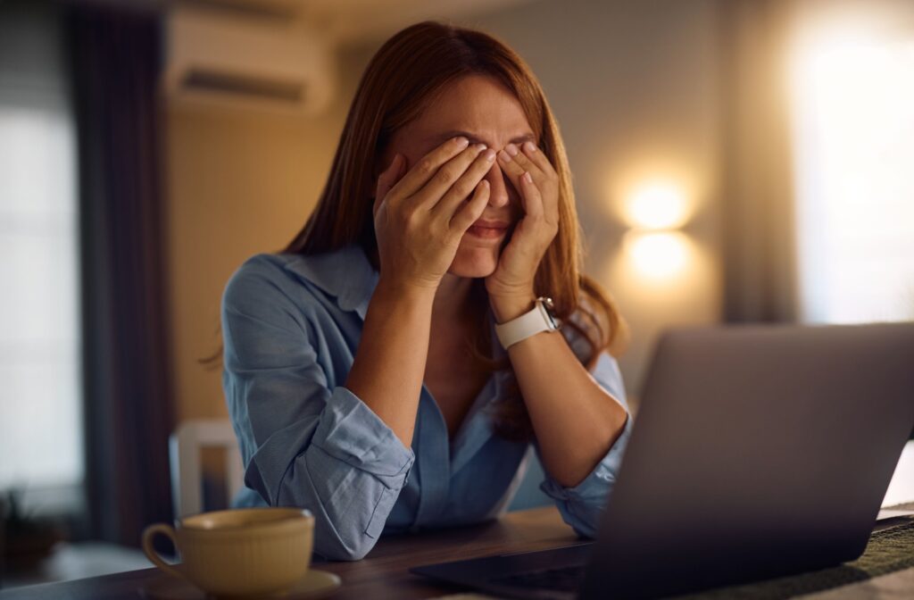 A person rubbing their eyes after staring at a computer screen for a long period of time.