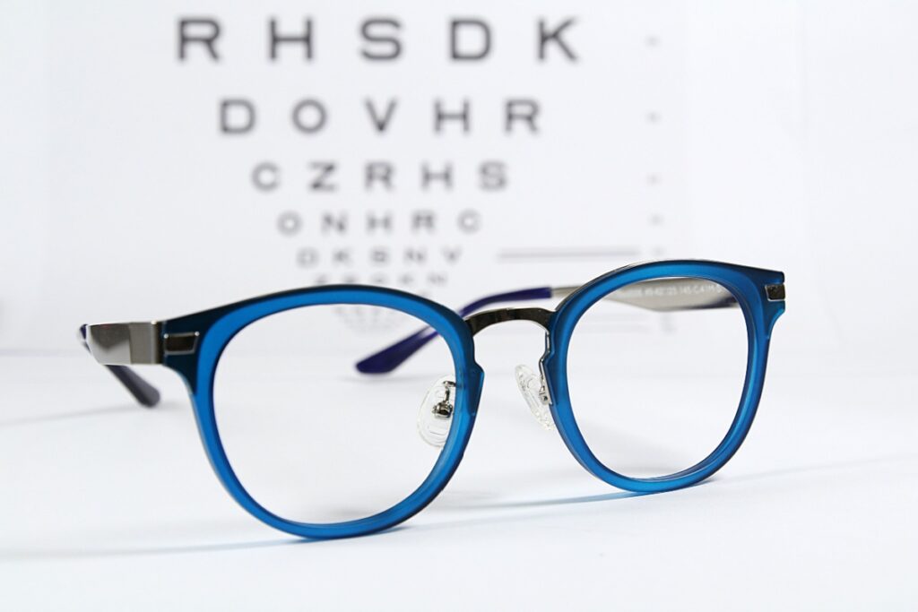 A pair of glasses in front of an eye chart.