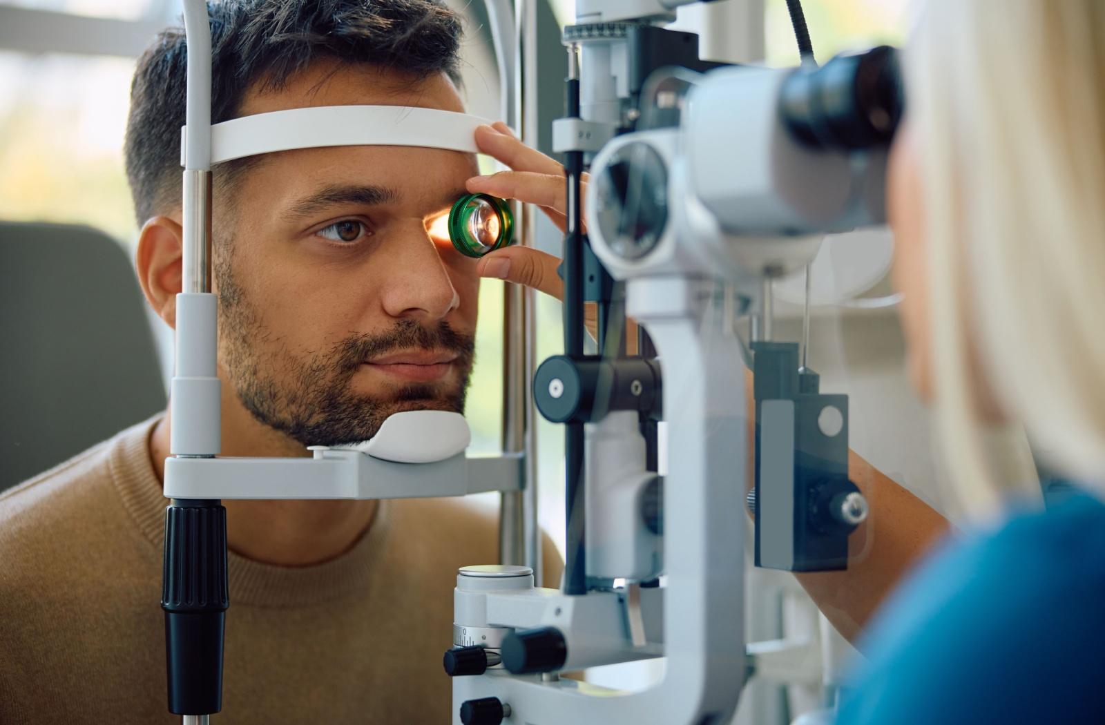 An optometrist examining a patient's eye with a slit lamp during a comprehensive eye exam.