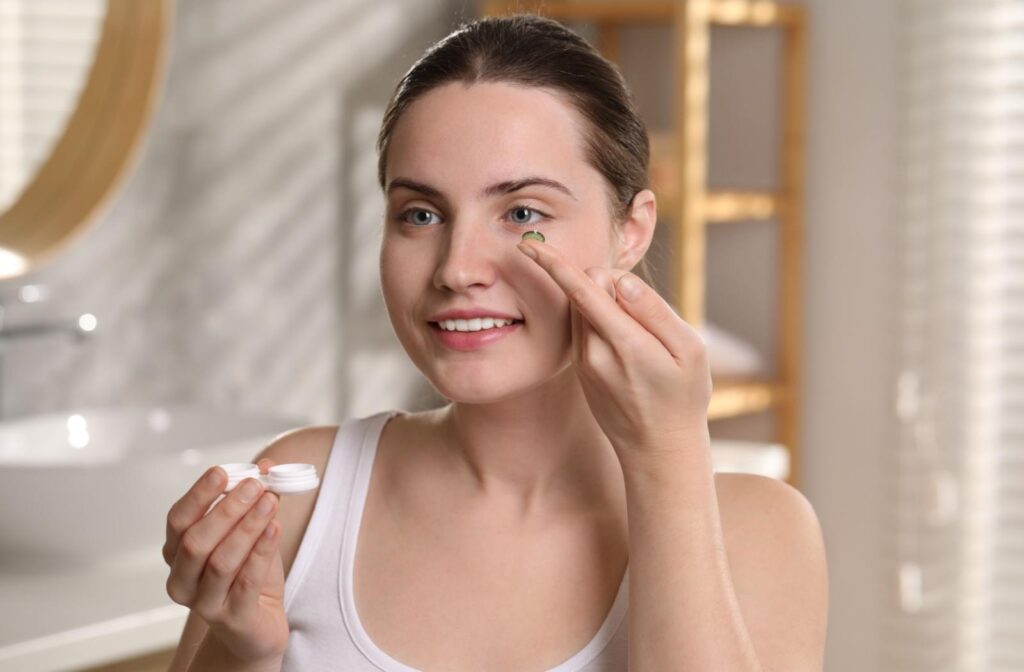 A person in the bathroom, inserting their contact lenses first thing in the morning to wear all day.